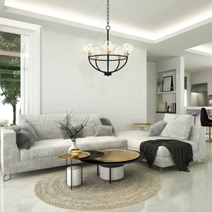 5 light Global view chandelier in grey tone living room. Hanging above a round coffee table.
