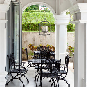 Botanic Arches outdoor pendant hanging on the outdoor patio above a table..
