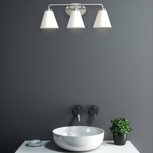 Regis vanity light in polished nickel with etched shade above a sing in a bathroom.