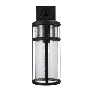 Amity Cylinder outdoor wall light with seeded glass lit.