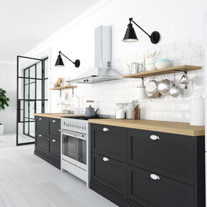 2 Moti swing arm wall sconces in black on the wall above kitchen counters..